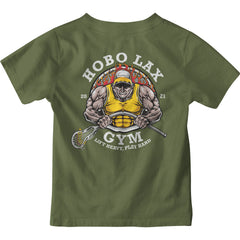 The Youth Lift Heavy Tee by Hobo Lax is a military green T-shirt showcasing a muscular man in a yellow tank top and cap, lifting a barbell with a lacrosse stick. "Hobo Lax Gym" and "2021" are printed above, alongside the motto "Lift Heavy, Play Hard" below. Ideal for young athletes passionate about youth lacrosse.